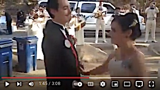 image of wedding couple dancing at park reception with Mariachi in background.